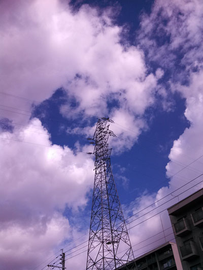 青空をバックに送電用の鉄塔が立っています